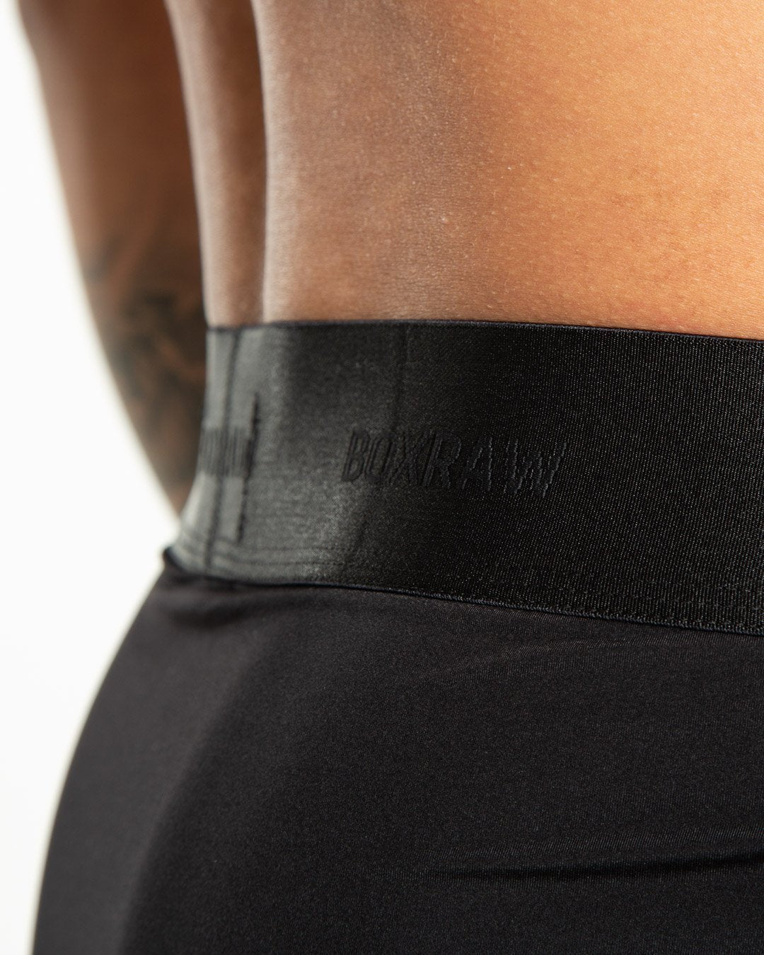 Man in black nylon slim fit boxers with white strike logo on waistband