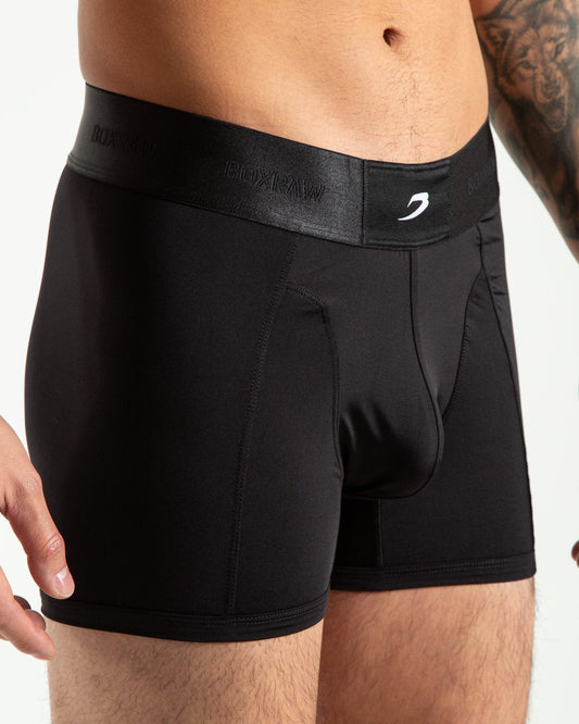 Man in black nylon slim fit boxers with white strike logo on waistband