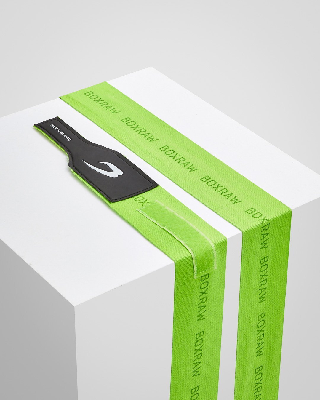 Neon green fabric boxing handwraps that is 4.5 metres in length with a leather velcro strap embossed with a white strike logo.