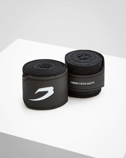 Black fabric boxing handwraps that is 3.5 metres in length with a leather velcro strap embossed with a white boxraw strike logo.