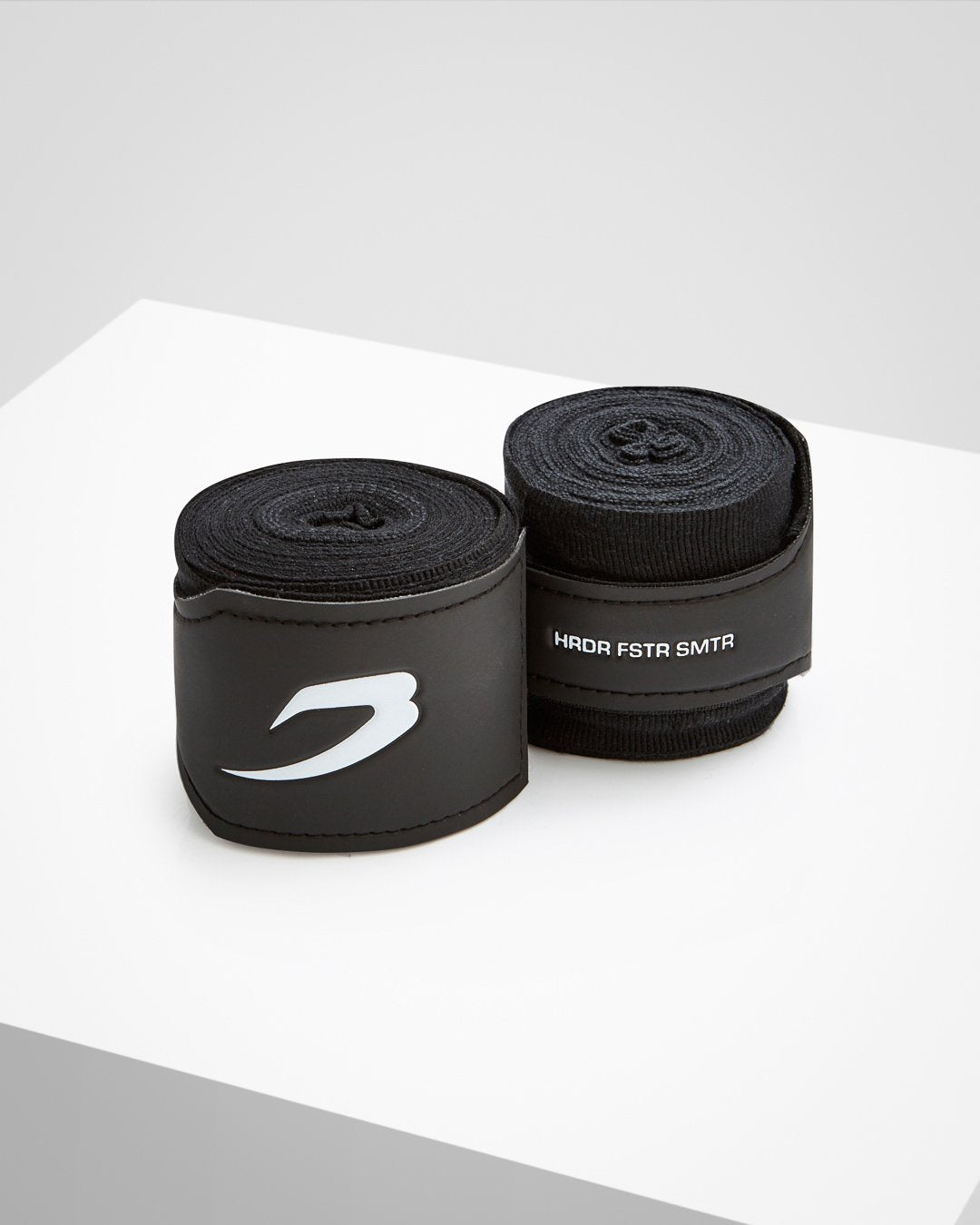 Black fabric boxing handwraps that is 4.5 metres in length with a leather velcro strap embossed with a white boxraw strike logo.