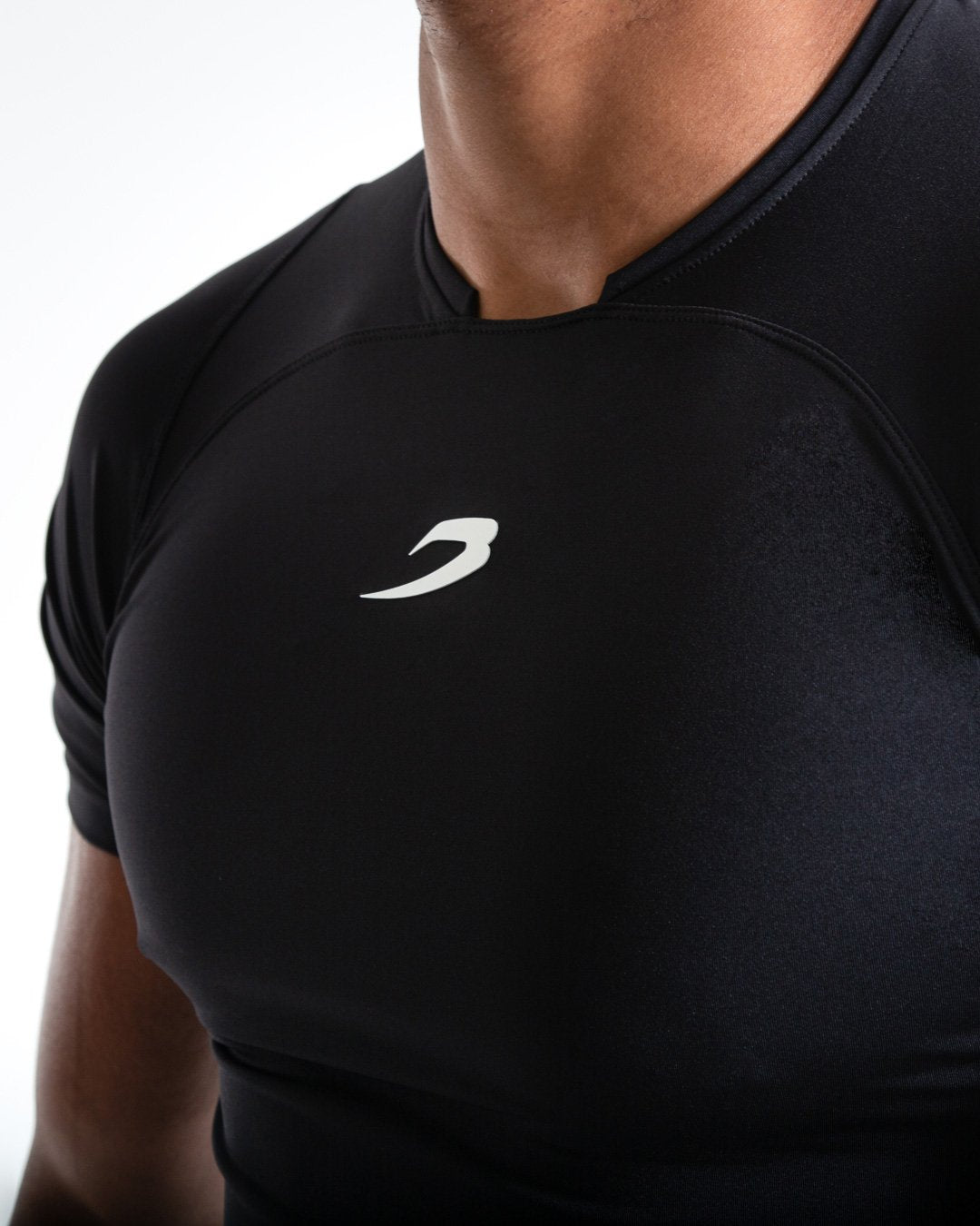 Man in black compression long sleeved t-shirt made from mesh fabric and targeted ventilation panels with white boxraw strike logo on the chest.