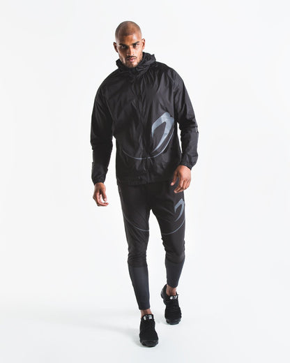 Man in slim fitting black lightweight tracksuit bottoms with reflective detailing and side zipped pockets
