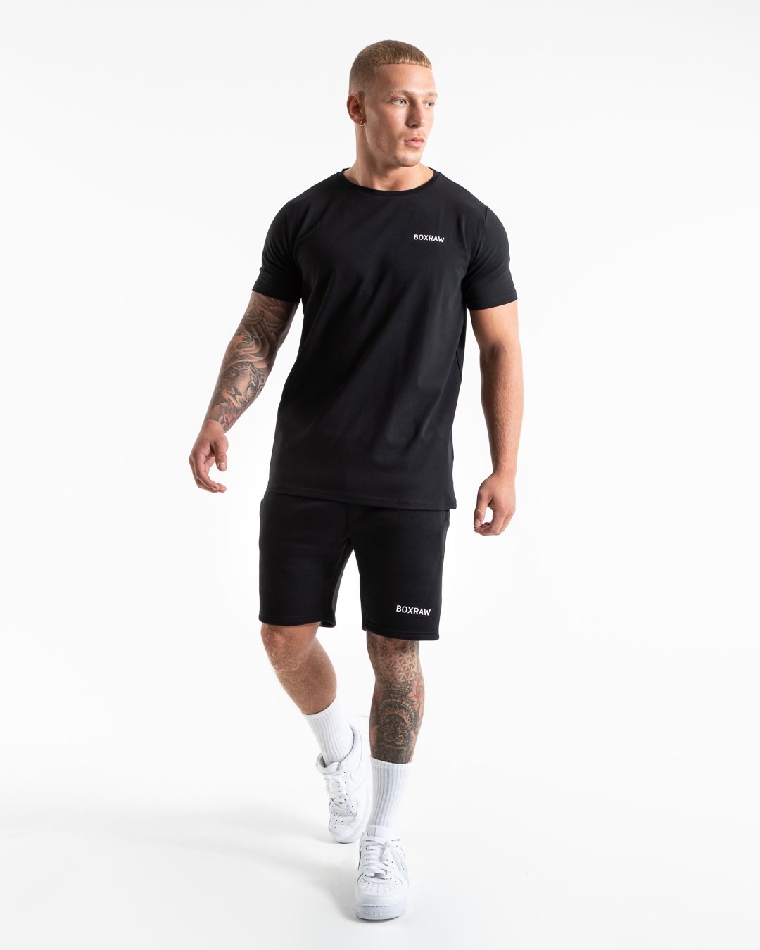 Man in black tracksuit style shorts with a white 3D boxraw logo as well as side zipped pockets made from a cotton/poly blend.