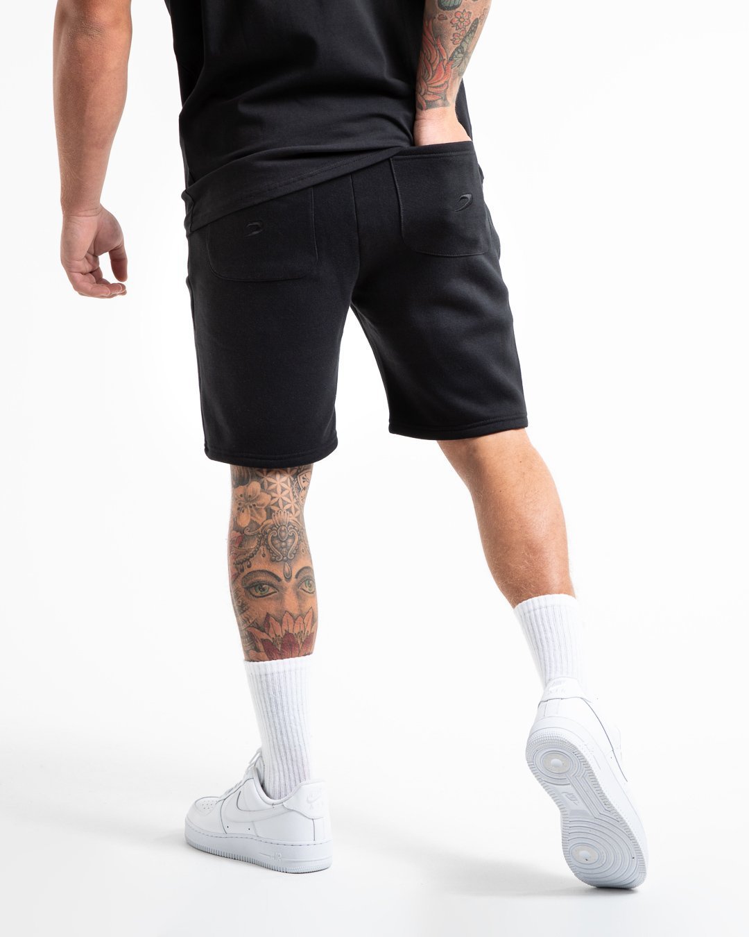 Man in black tracksuit style shorts with a white 3D boxraw logo as well as side zipped pockets made from a cotton/poly blend.