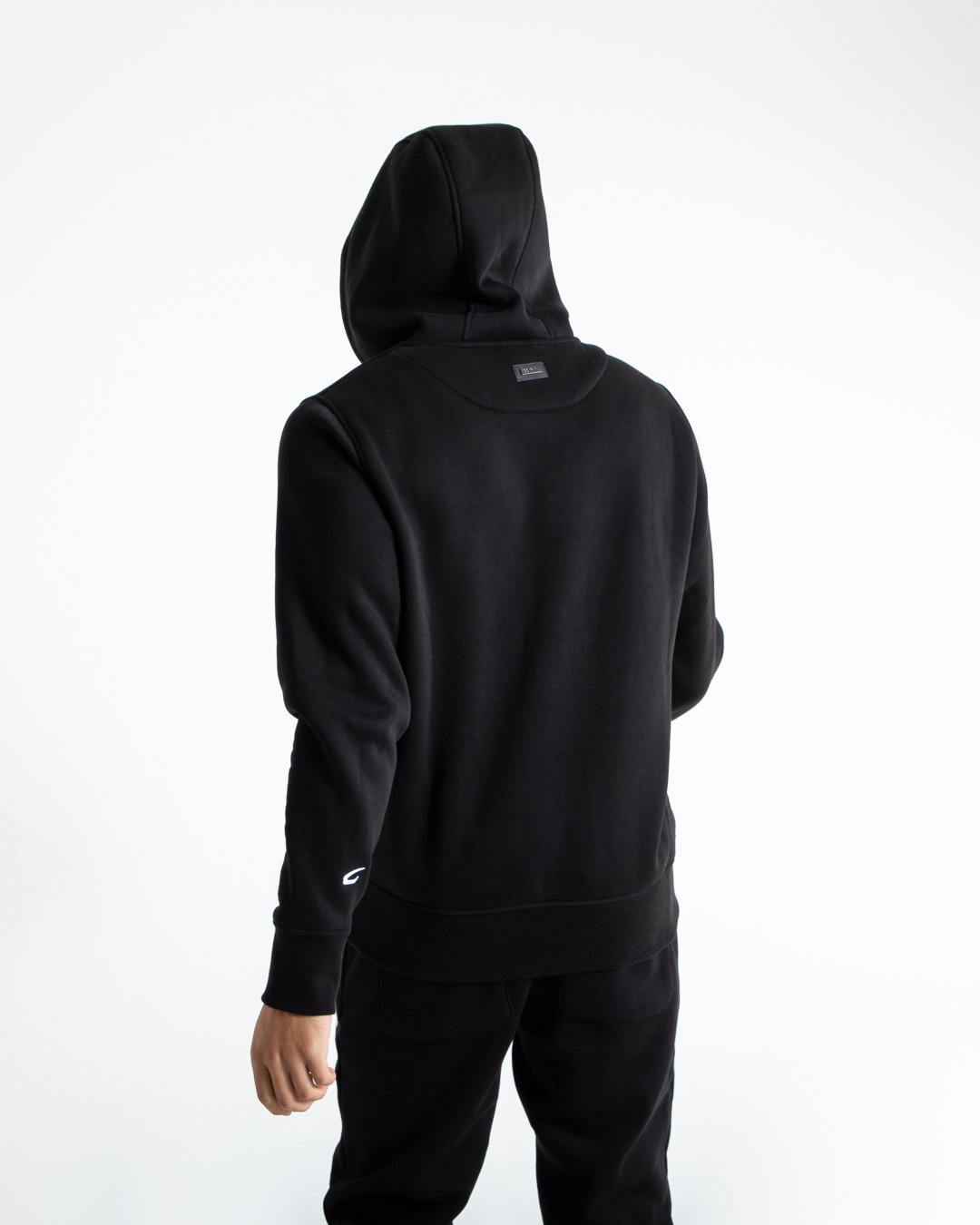 Man in black jumper with hood and kangaroo pouch as well as white 3D boxraw logo on the chest and embroidered strike logos on sleeves.