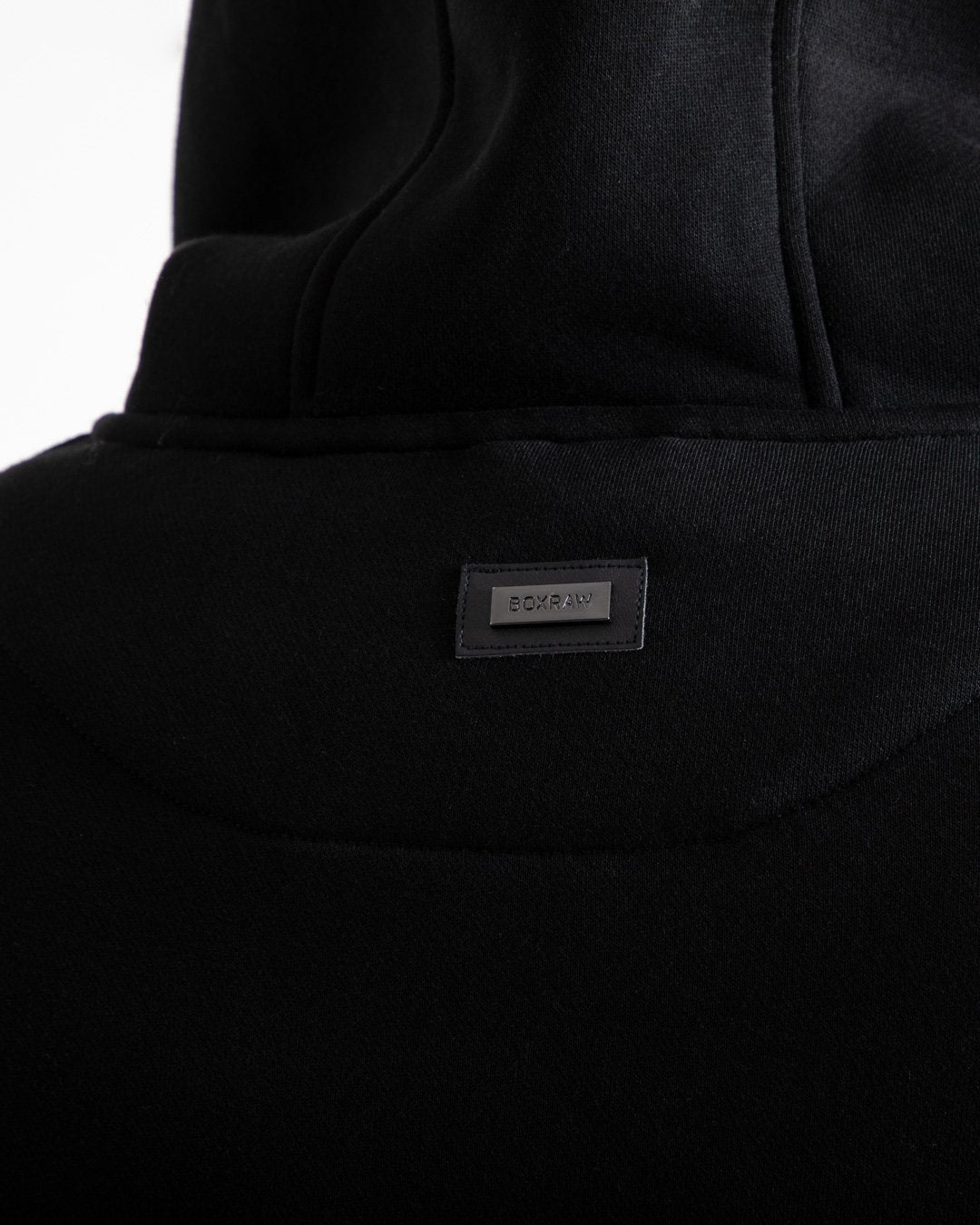 Man in black jumper with hood and kangaroo pouch as well as white 3D boxraw logo on the chest and embroidered strike logos on sleeves.