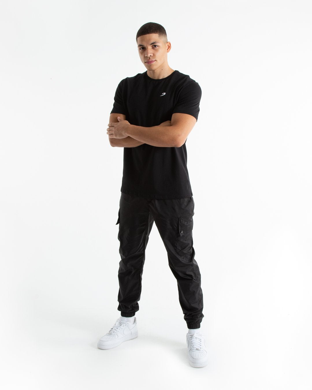 Man in tailored fit black t-shirt with embroidered boxraw strike logo made from stretch cotton.