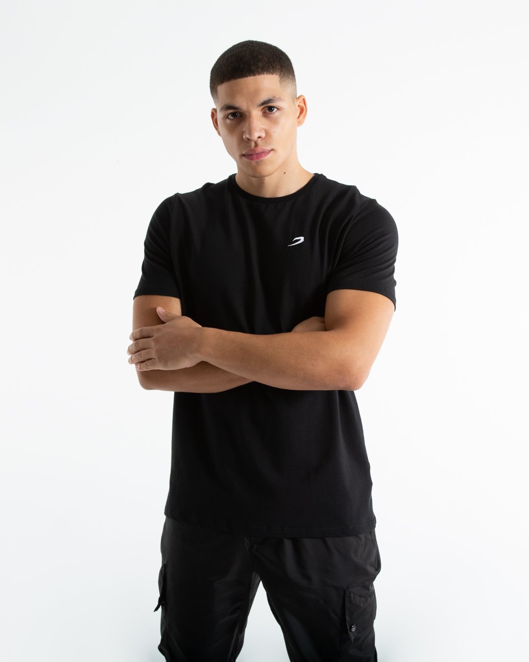 Man in tailored fit black t-shirt with embroidered boxraw strike logo made from stretch cotton.