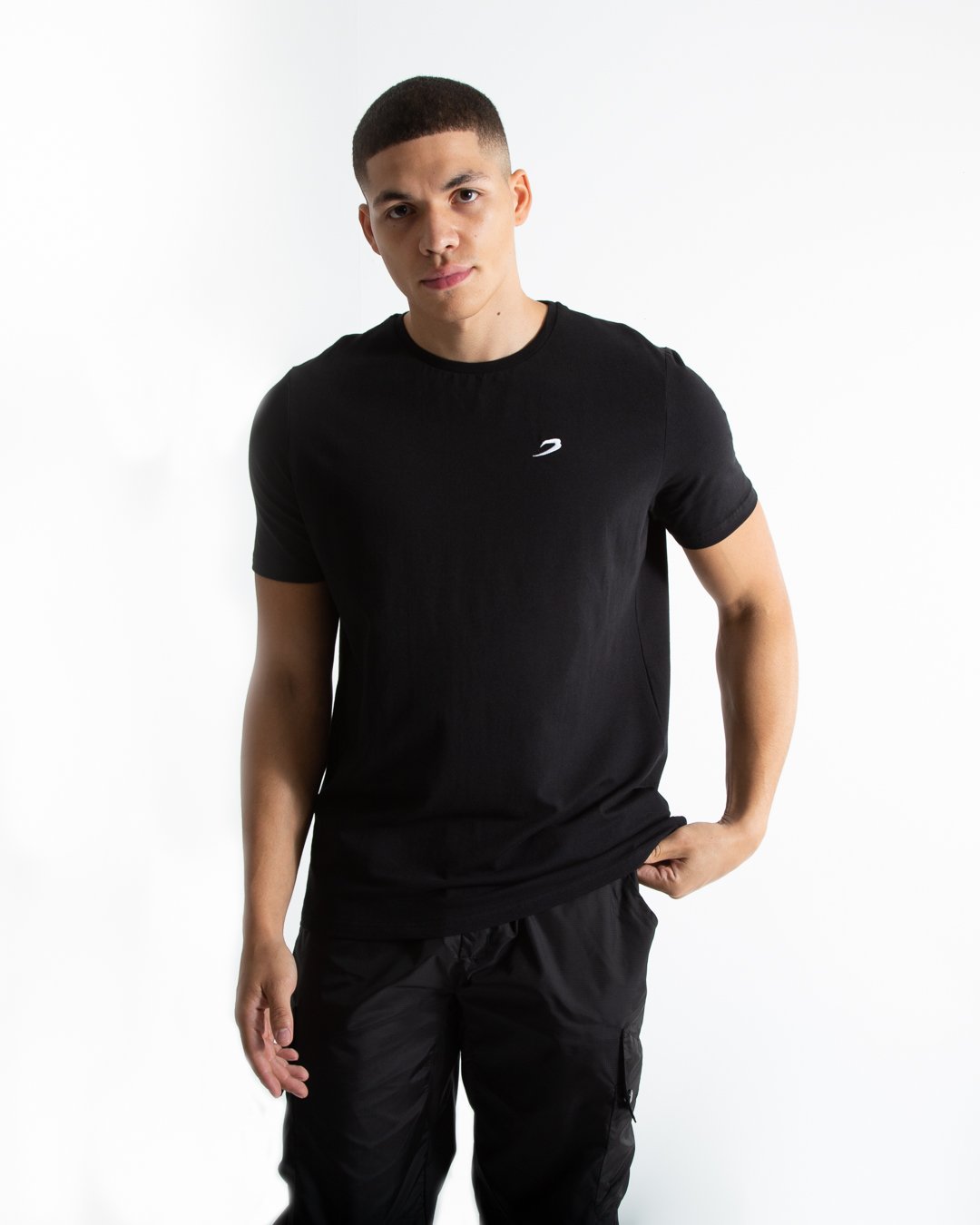 Man in tailored fit black t-shirt with embroidered boxraw strike logo made from stretch cotton.