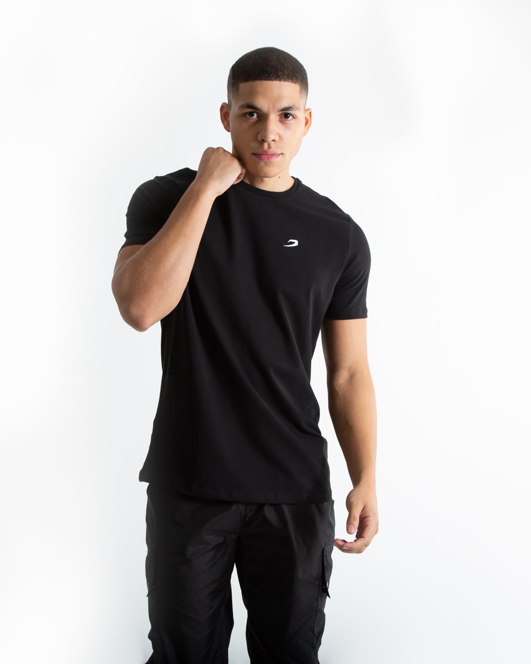 Man in tailored fit black t-shirt with embroidered boxraw strike logo made from stretch cotton.