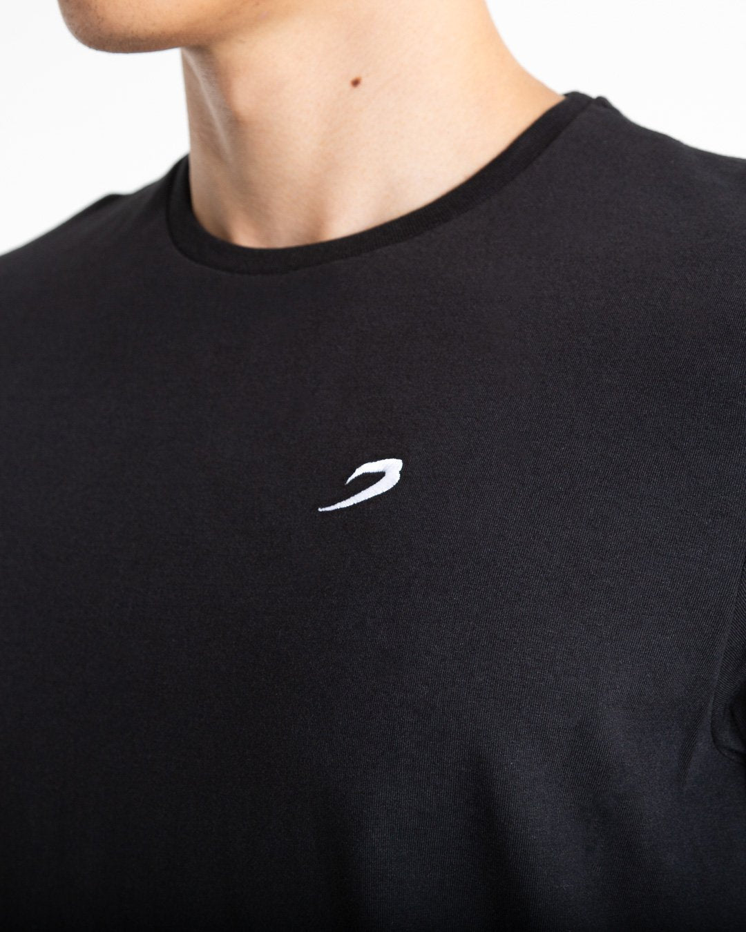 Man in tailored fit black t-shirt with embroidered boxraw strike logo made from stretch cotton.