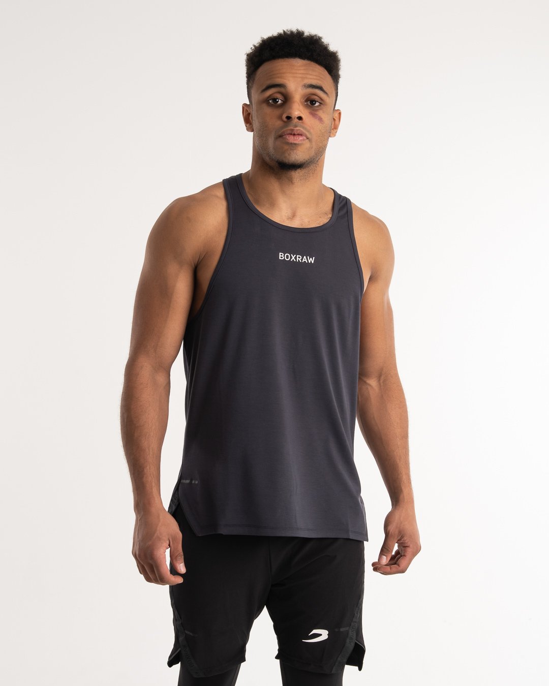 man wearing charcoal dark grey boxraw performance stringer tank top
