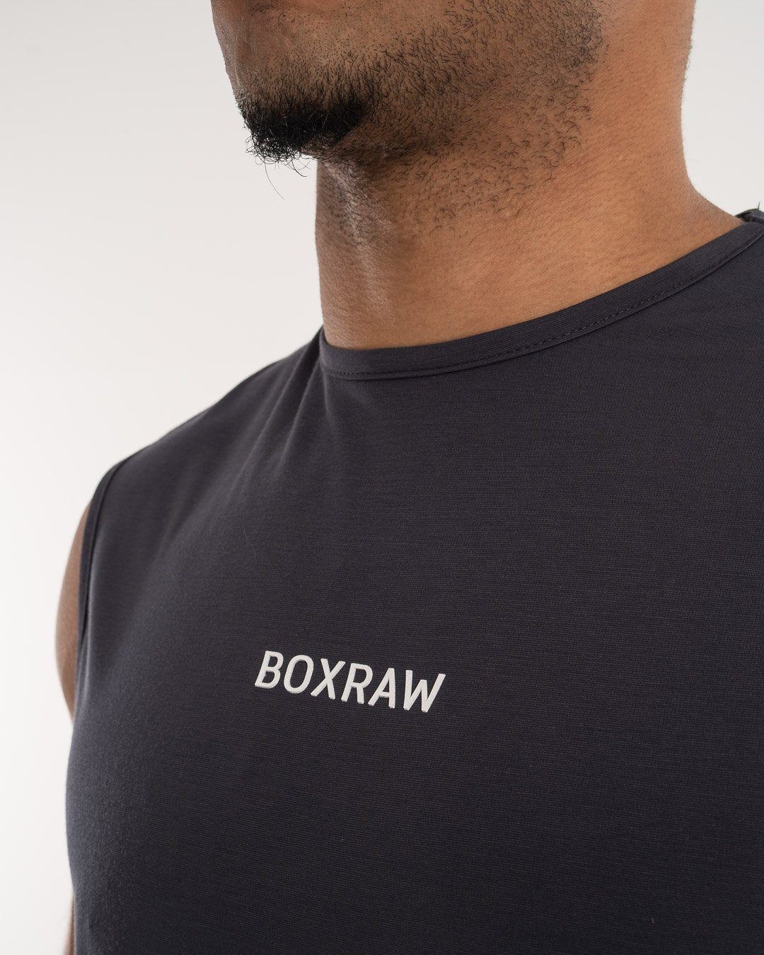 man wearing charcoal dark grey boxraw performance muscle fit tank top
