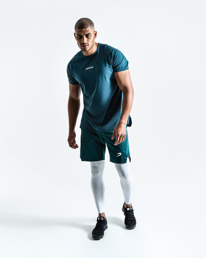 Man in green training shorts made from polyester with white compression leggings inside made from cotton with deep side pocket with a white strike logo.