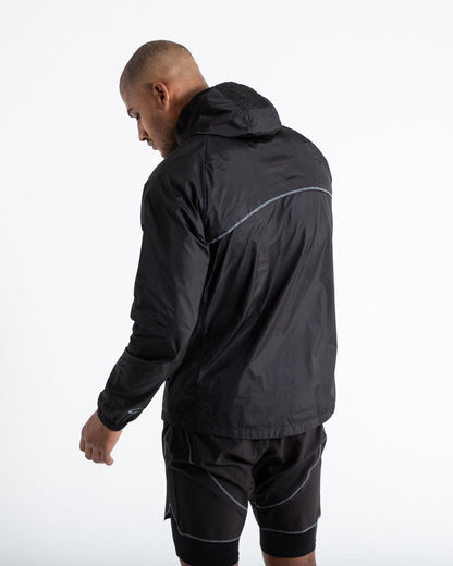 Man in black zipped windbreaker with hood and reflective big boxraw strike logo across left body panel made from nylon.