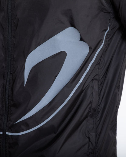 Man in black zipped windbreaker with hood and reflective big boxraw strike logo across left body panel made from nylon.