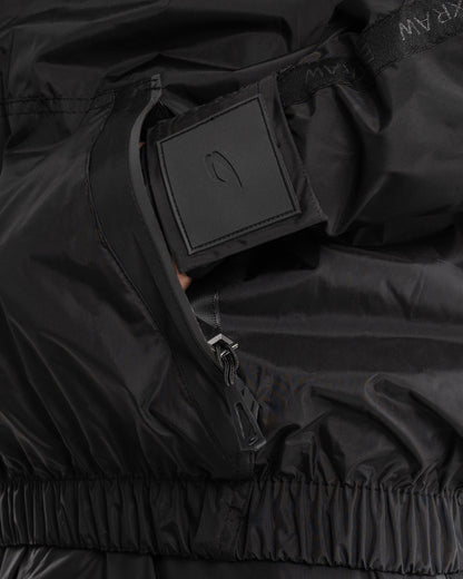 Man in a black sauna suit tracksuit with a white boxraw logo on the chest as well as adjustable wrist straps and made from polyester.