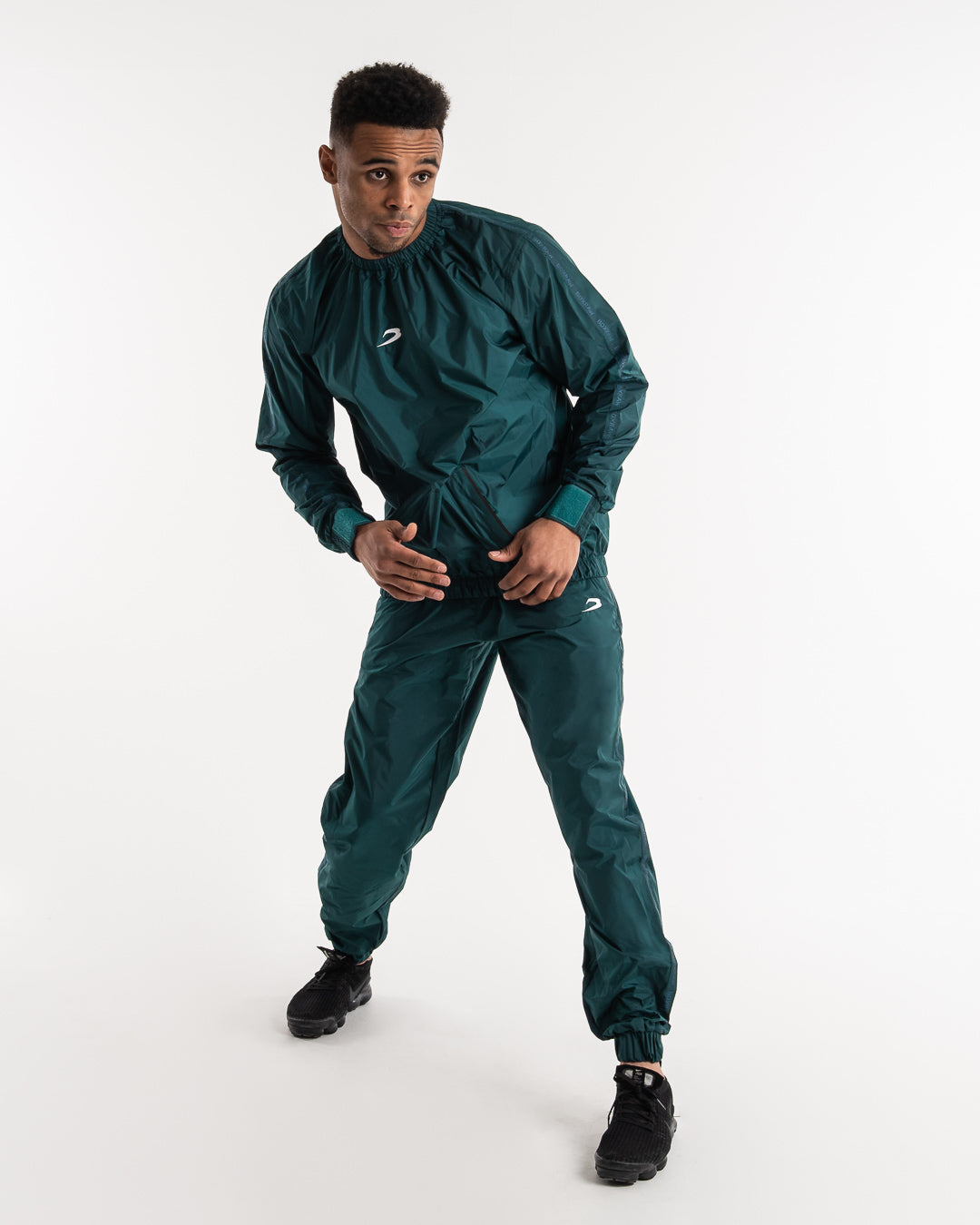 Man in a green sauna suit tracksuit with a white boxraw logo on the chest as well as adjustable wrist straps and made from polyester.