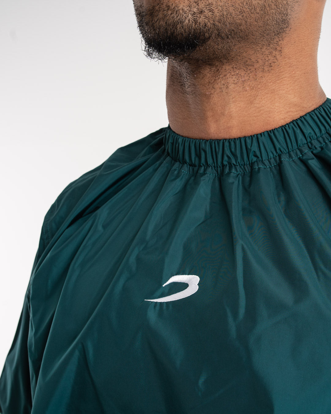 Man in a green sauna suit tracksuit with a white boxraw logo on the chest as well as adjustable wrist straps and made from polyester.