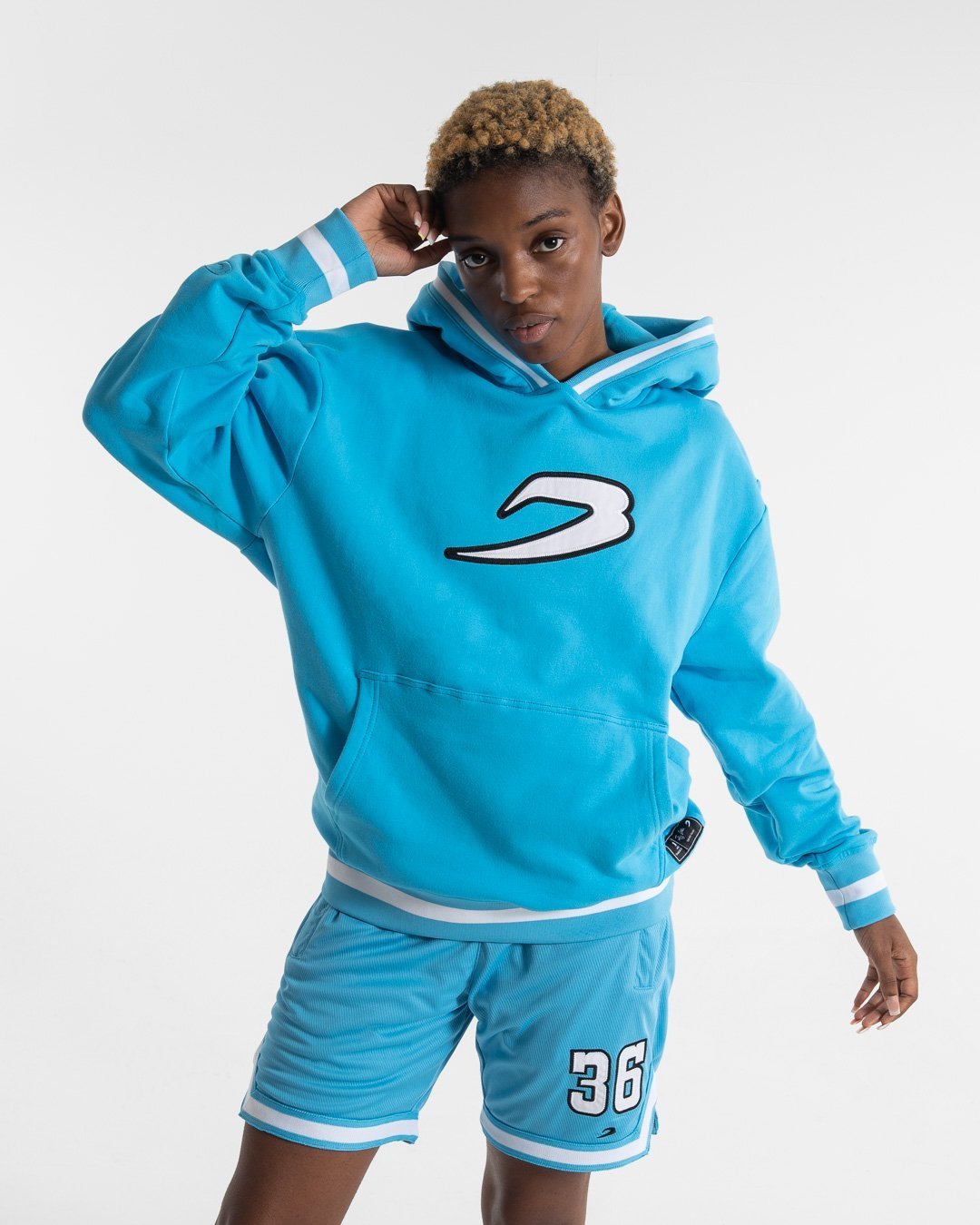 Women in a boxraw baby blue jumper with hood & kangaroo pocket made from cotton with the boxraw strike logo in white on the front and large 36 number on the back.
