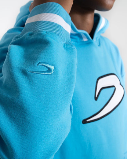 Women in a boxraw baby blue jumper with hood & kangaroo pocket made from cotton with the boxraw strike logo in white on the front and large 36 number on the back.