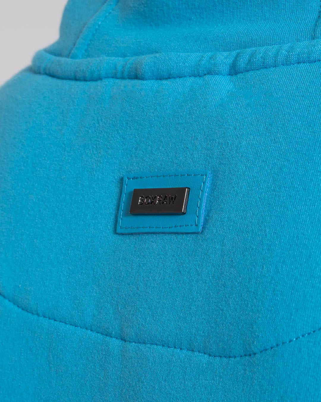 Women in a boxraw baby blue jumper with hood & kangaroo pocket made from cotton with the boxraw strike logo in white on the front and large 36 number on the back.