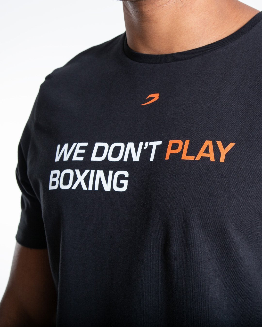 Man in black slim fit cotton t-shirt with we dont play boxing text in white on chest.