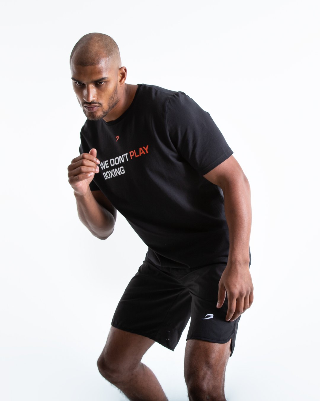 Man in black slim fit cotton t-shirt with we dont play boxing text in white on chest.