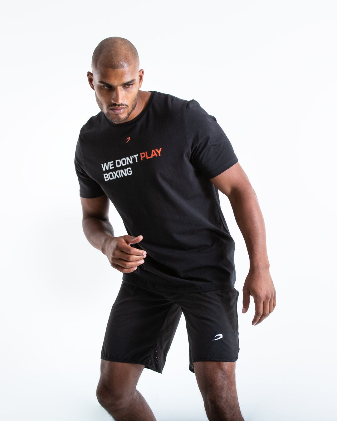 Man in black slim fit cotton t-shirt with we dont play boxing text in white on chest.