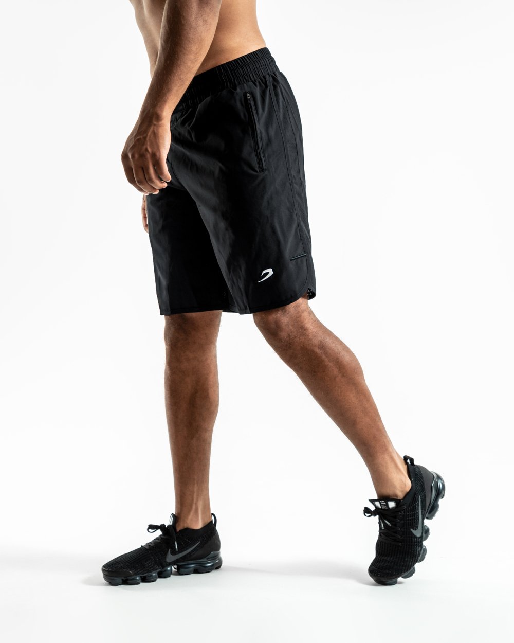 Man in black training shorts with adjustable waistband and side zipped pockets as well as an embroidered white boxraw strike logo.