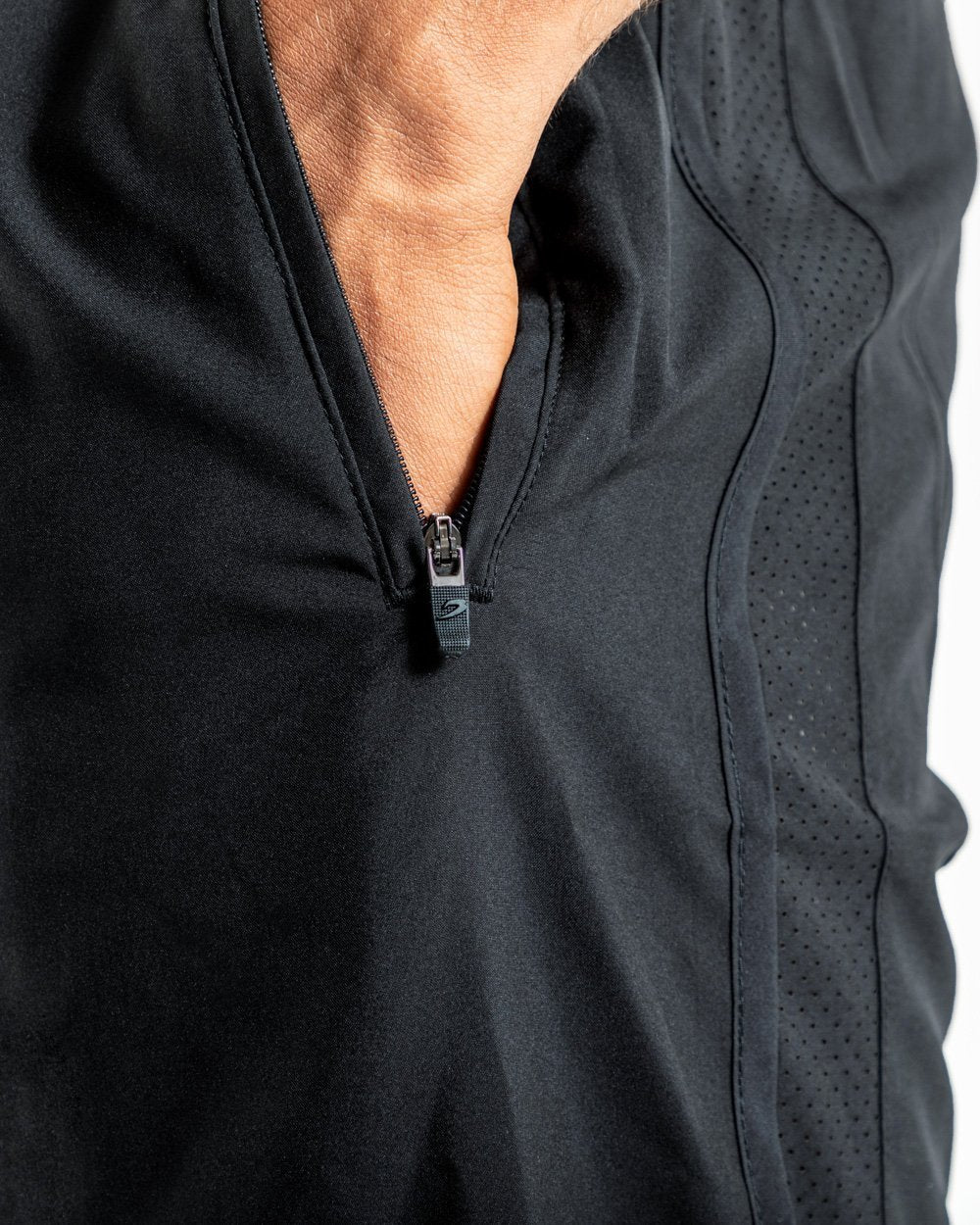Man in black training shorts with adjustable waistband and side zipped pockets as well as an embroidered white boxraw strike logo.