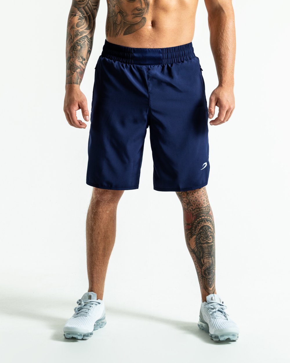 Man in navy training shorts with adjustable waistband and side zipped pockets as well as an embroidered white strike logo.