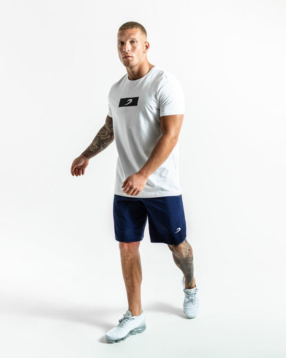 Man in navy training shorts with adjustable waistband and side zipped pockets as well as an embroidered white strike logo.