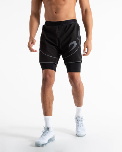 Man in black shorts with compression shorts underlayer with reflective detailing and side zipped pockets