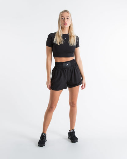 Women in black high waisted shorts with woven strike logo waistband patch