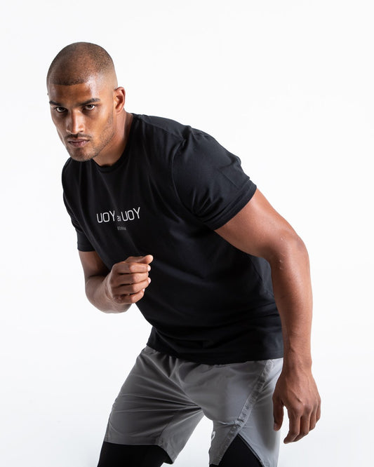 Man in black slim fit cotton t-shirt with reversed you vs you text in white on chest.
