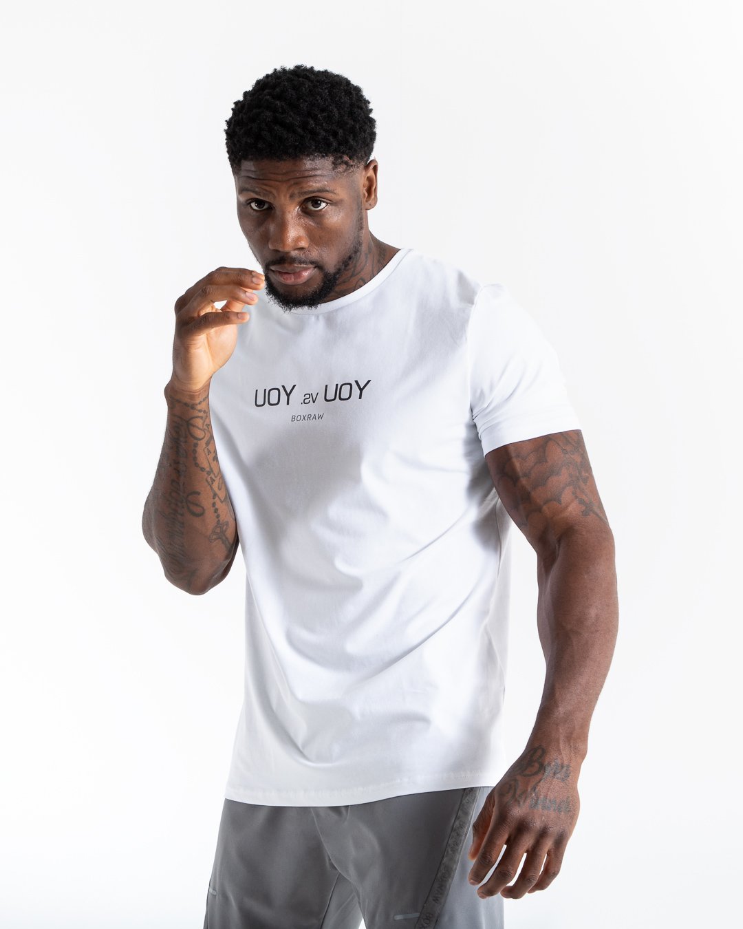 Man in white slim fit cotton t-shirt with reversed you vs you text in black on chest.