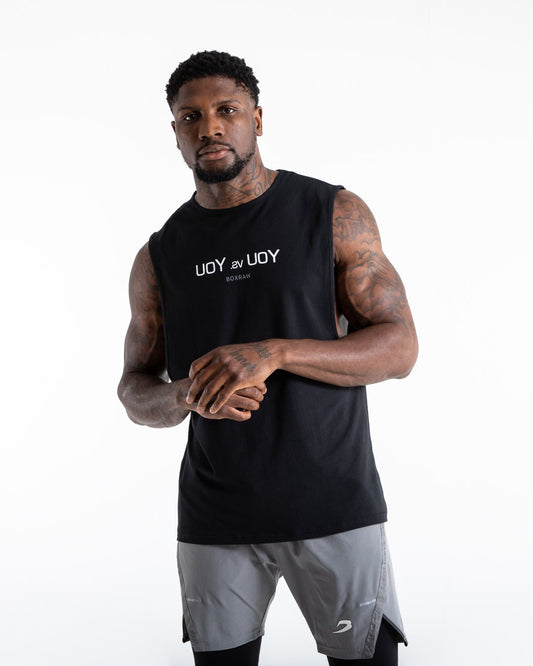 Man in black slim fit cotton muscle tank with reversed you vs you text in white on chest.