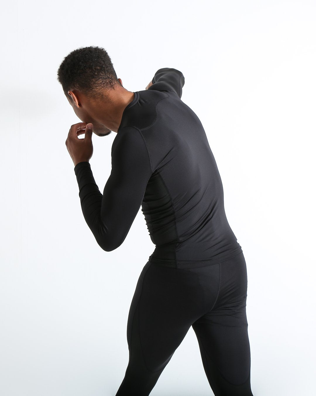Man in black compression long sleeved t-shirt made from mesh fabric and targeted ventilation panels with white boxraw strike logo on the chest