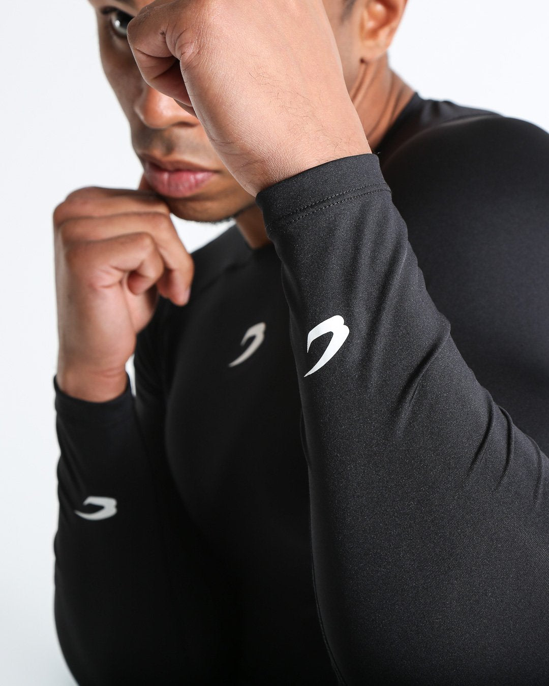 Man in black compression long sleeved t-shirt made from mesh fabric and targeted ventilation panels with white boxraw strike logo on the chest