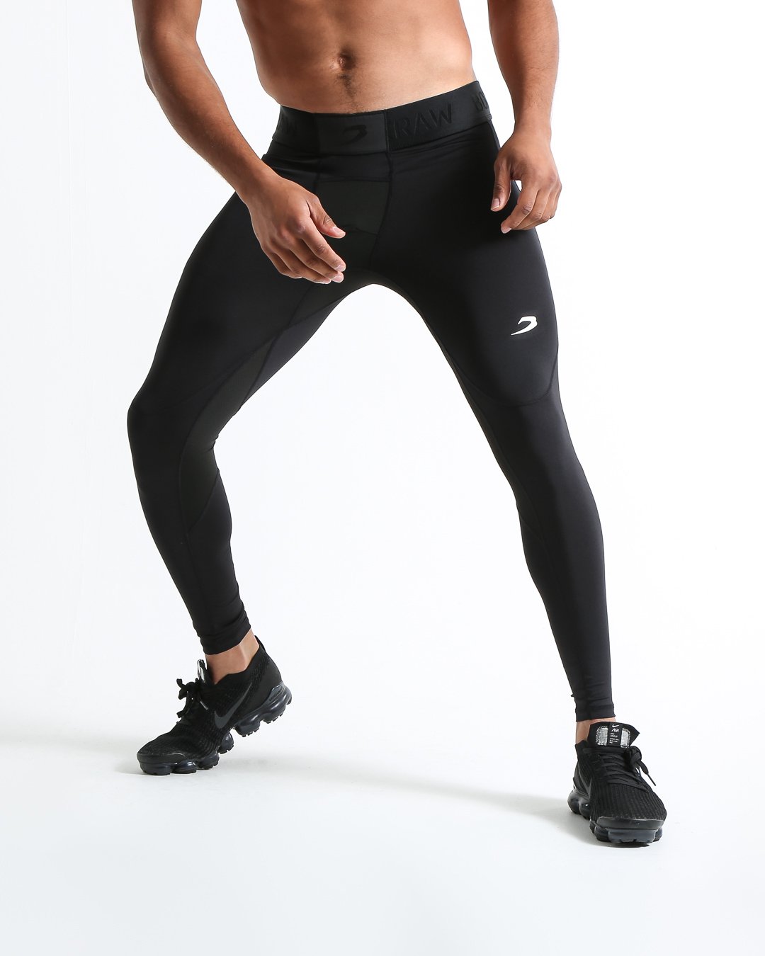 Man in black compression leggings/tights with wide elastic waistband and a white 3D strike logo on the leg.