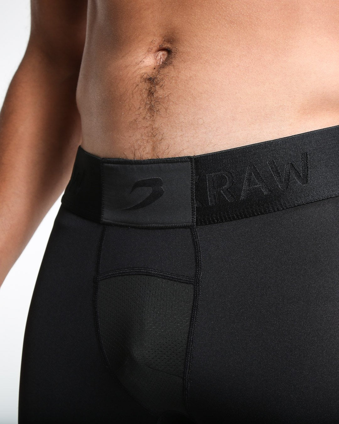 Man in black compression leggings/tights with wide elastic waistband and a white 3D strike logo on the leg.